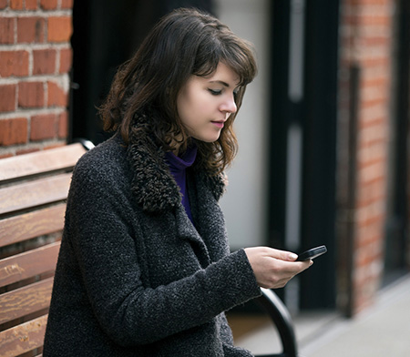 young woman on a bench looking at her phone
