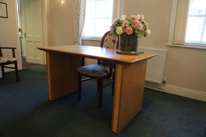 A plain signing desk with flowers ontop