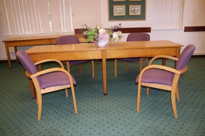The main table used to sign ceremonies at Witney Ceremony Room, adorned with flowers with two chairs in front.